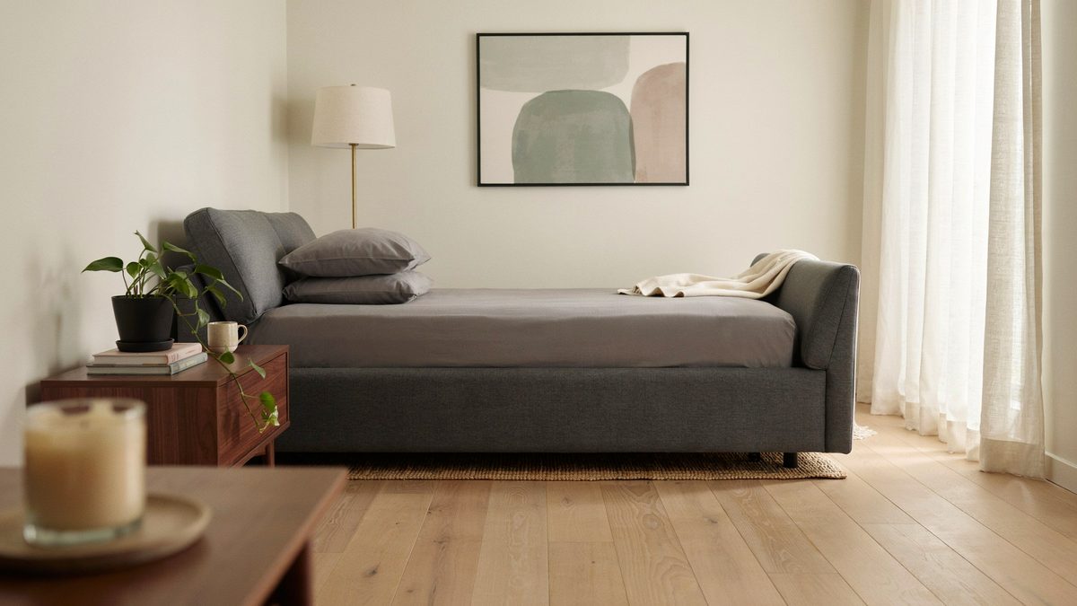 Gray sleeper sofa opened flat into a bed in a bright living room