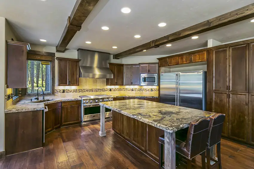 Craftsman style kitchen with solid wood cabinets granite countertops wood plank flooring wood beams