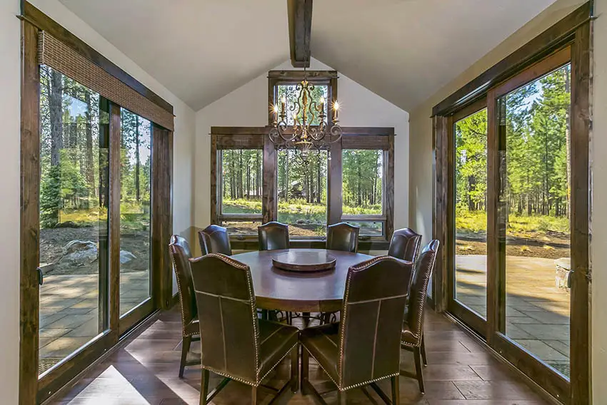 Dining room with wraparound windows round table vaulted ceiling with single beam