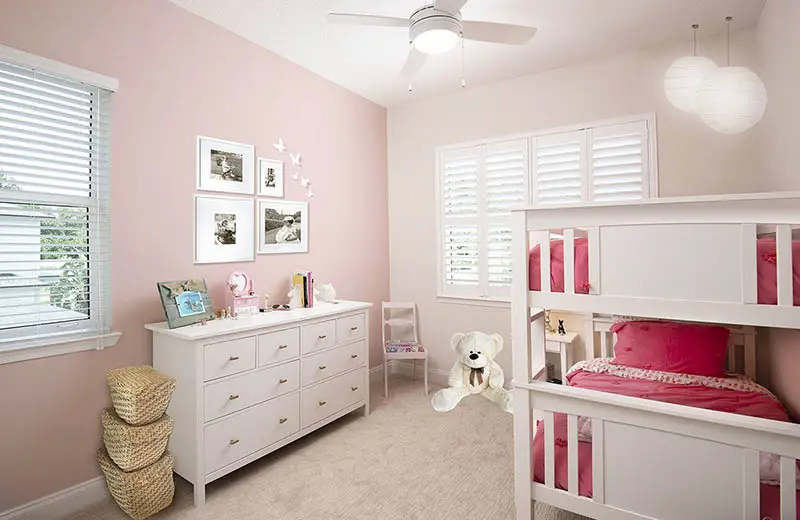 Girls bedroom with pink off white painted walls bunk beds globe pendant light