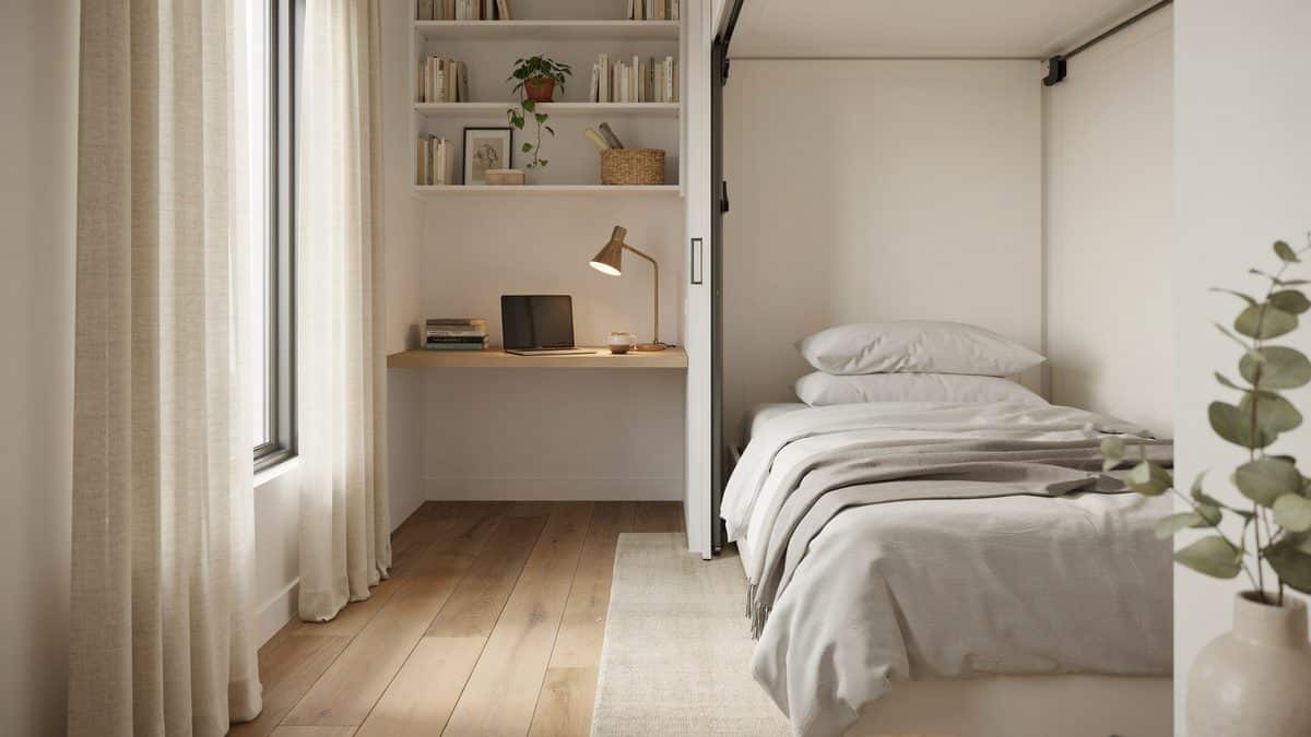 Home office nook with built in desk and shelves next to an open wall bed