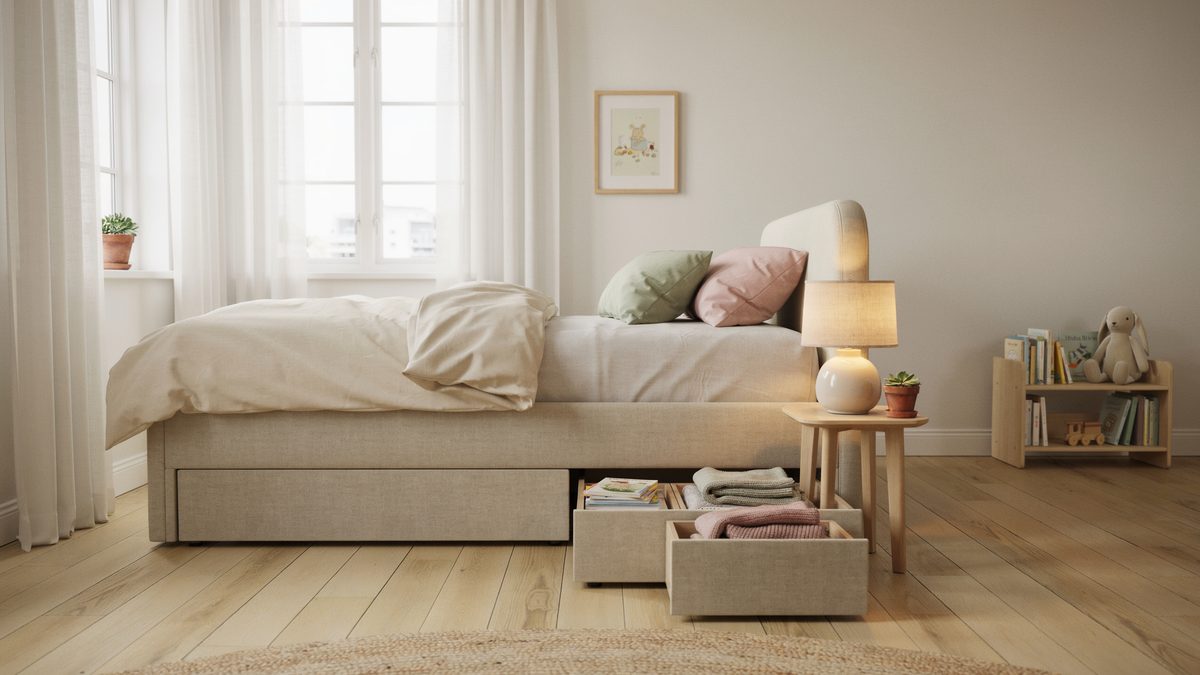 Cream upholstered divan bed with two base drawers pulled open on light flooring