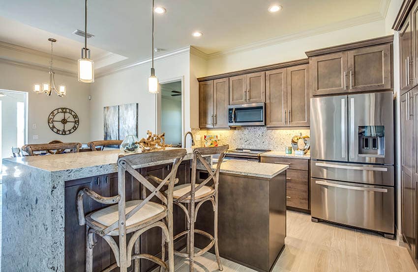 Kitchen with two tier island raised breakfast bar with bar stools lower meal prep area