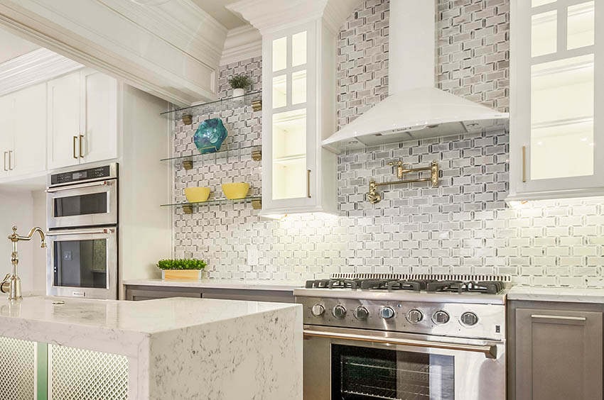 Kitchen with white hood, laminated counter, steel oven and windows