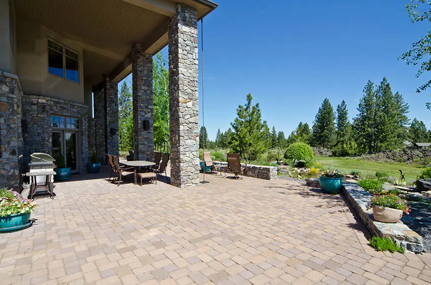 Large backyard paver patio with covered dining table