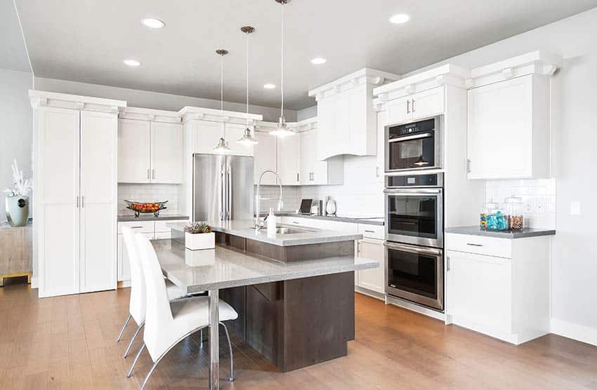 Modern kitchen with two tiered island with seating and gray quartz countertops