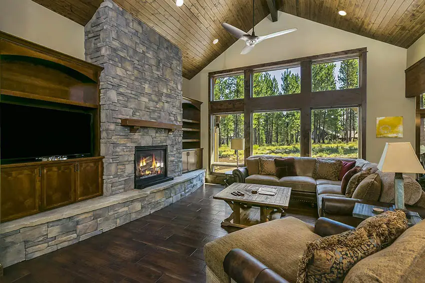 Mountain craftsman living room with vaulted ceiling wood planking stone fireplace wood mantel