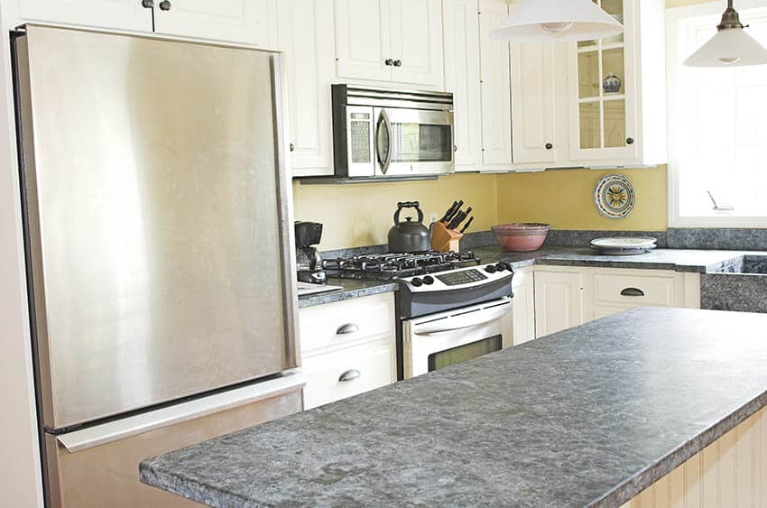 Kitchen with beadboard island, yellow backsplash and white cabinets