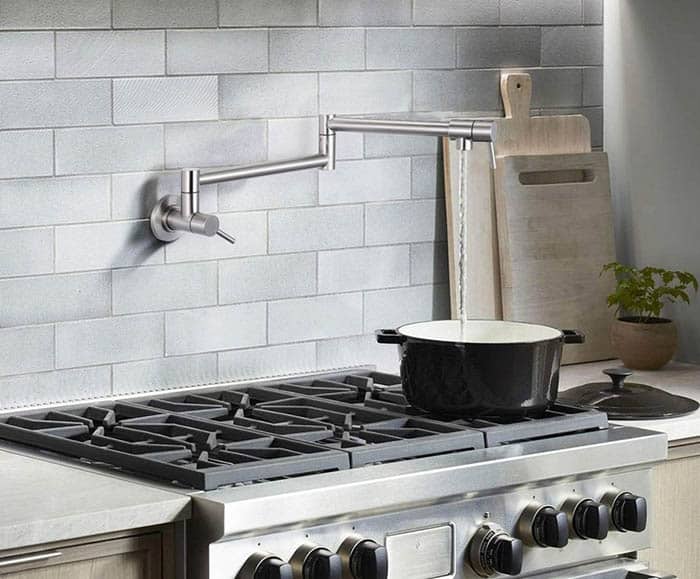 White backsplash, steel stove with pot on top