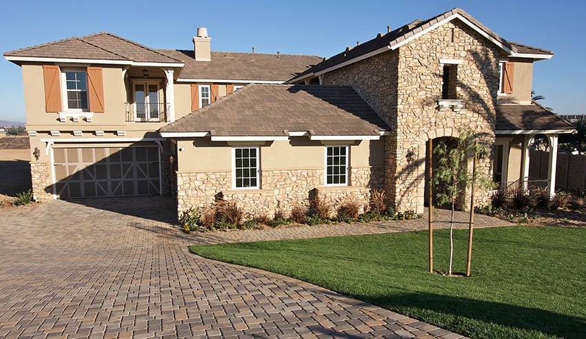 Stone and stucco house with brown roof