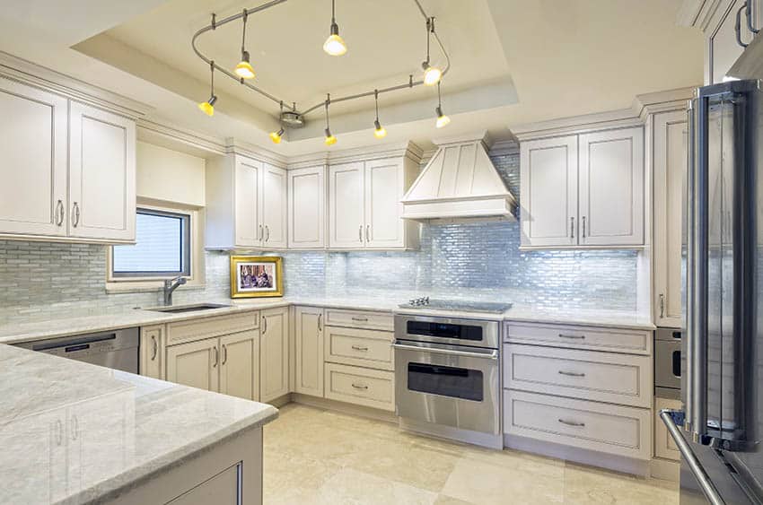 Track lighting in traditional kitchen with off white cabinets 