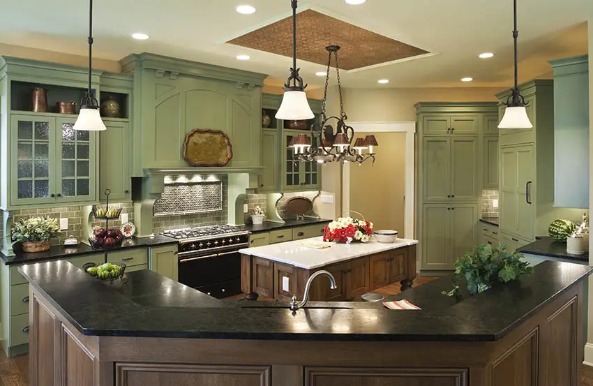 Traditional kitchen with black solid surface countertops breakfast bar island with green cabinets
