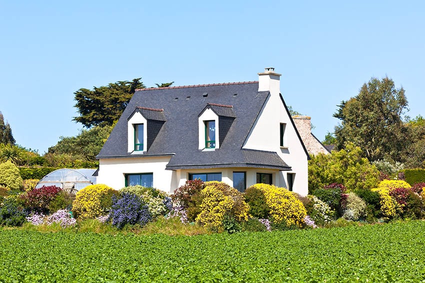White french country house with dark gray roof