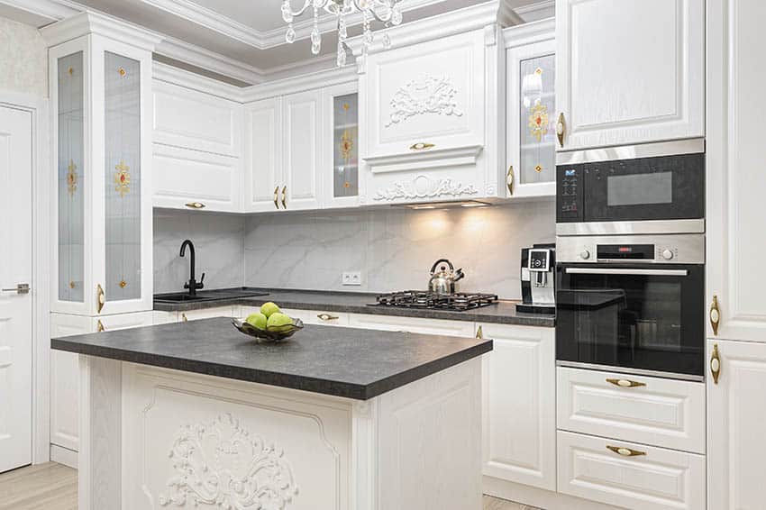 White kitchen withdecorative moldings on island and top cabinets