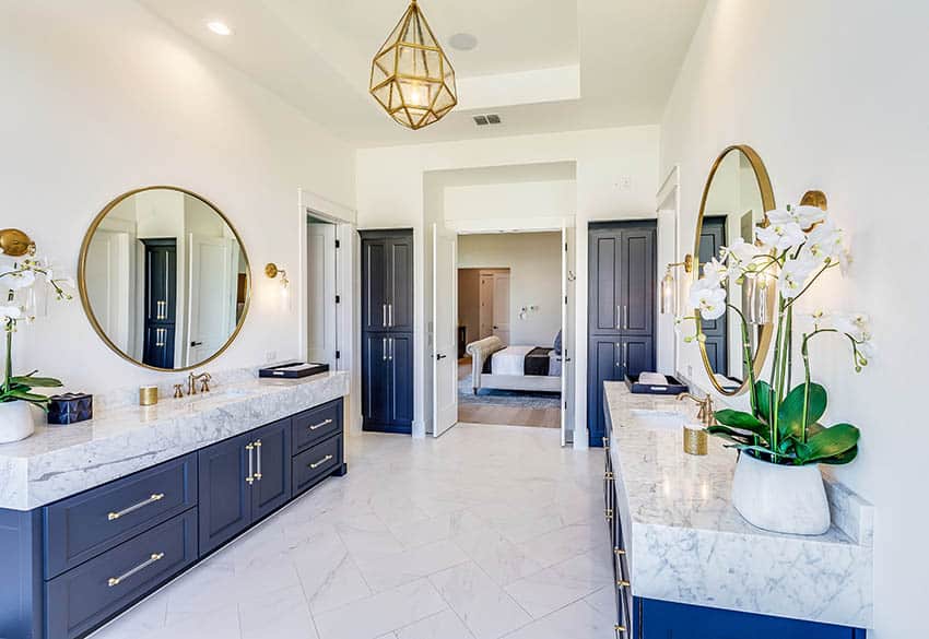 Bathroom with blue dual vanities and thick corian countertops gold light fixture