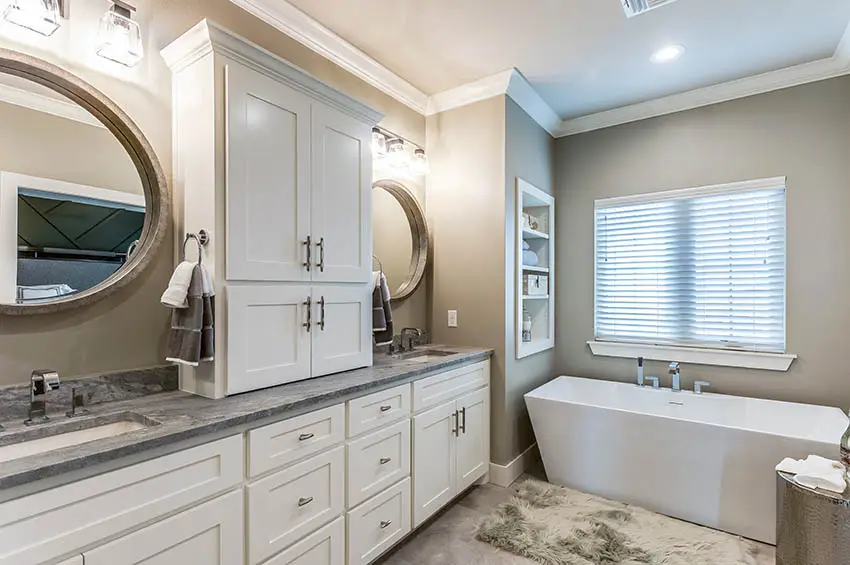 Bathroom with dual vanities waterfall faucets white cabinets contemporary tub