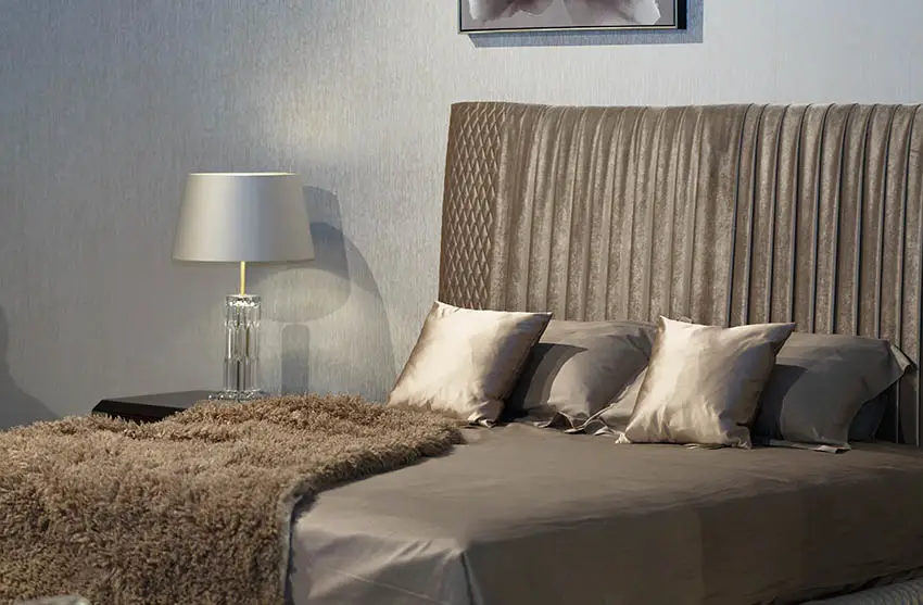 Bed with grey silk sheets decorative pillows