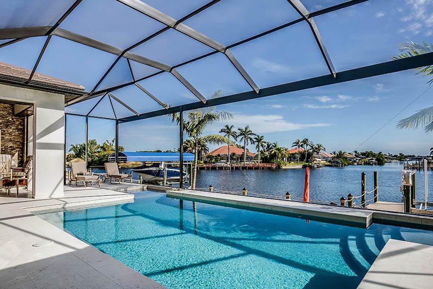 Covered backyard swimming pool with waterfront views