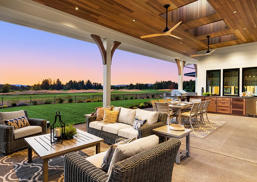 Covered exposed aggregate patio with outdoor furniture golf course views