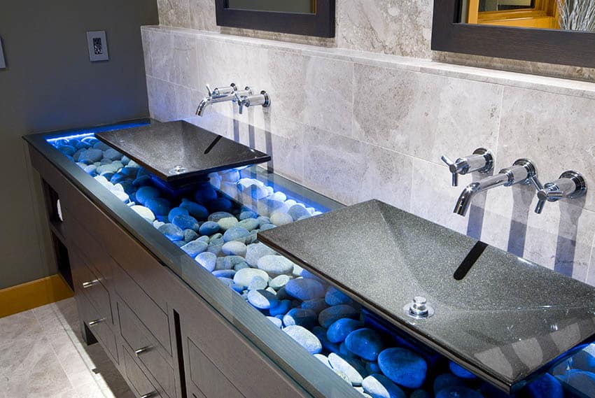 Double sink vanity with wall mounted faucets and river rocks