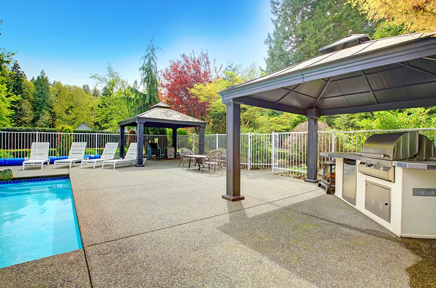 Pebble aggregate patio with pergola and outdoor kitchen