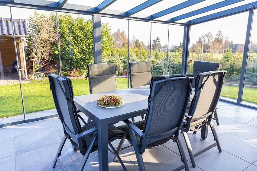 Patio with dining set surrounded by glass walls 