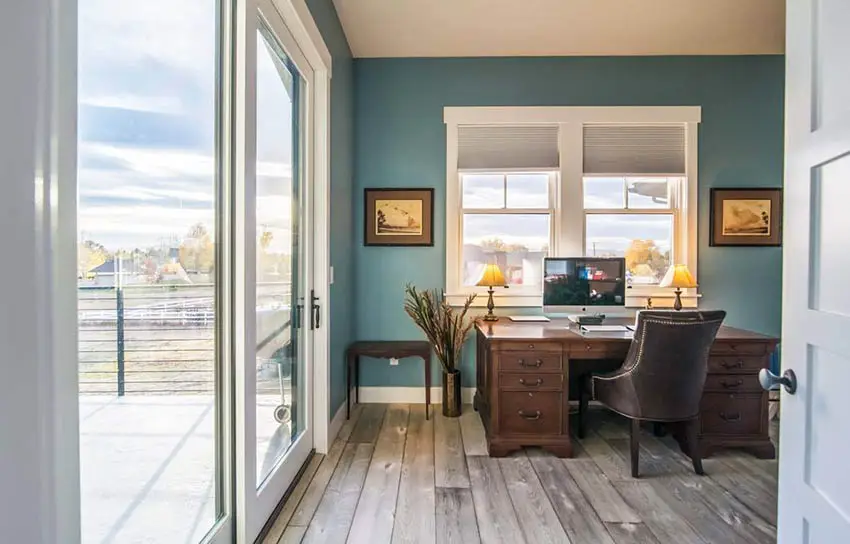 Home office with aqua blue walls wood flooring white frame windows