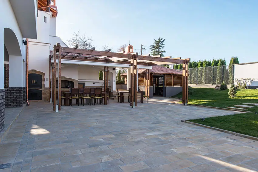 Irregular cut bluestone paver patio with pergola and outdoor kitchen