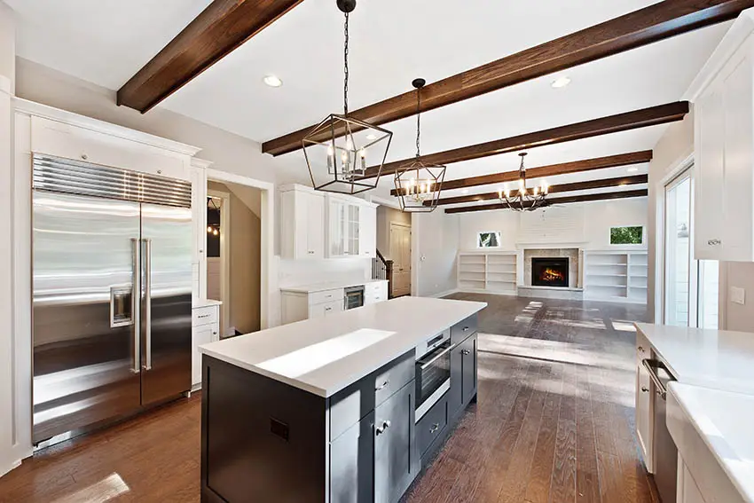 Kitchen with spc flooring white cabinets black island wood beams ceiling