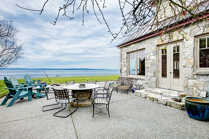 Large aggregate stone patio next to stone house