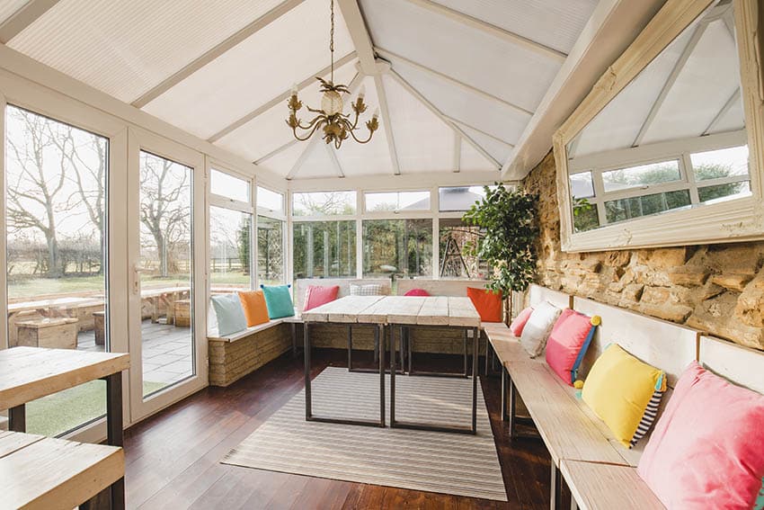 Patio with bench seating, colorful pillows and chandelier