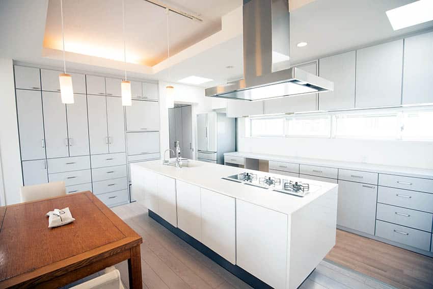 Modern kitchen with white solid surface countertops white island grey cabinets