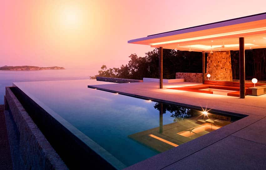 Modern l shaped swimming pool with infinity edge and pavilion