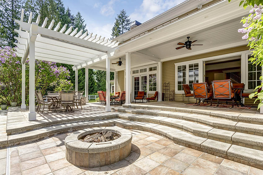 Patio with fire pit and raised concrete patio with pergola and outdoor dining table