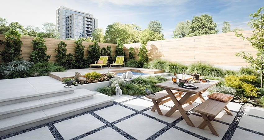 Raised concrete patio design with elevated wood deck above splash pool and garden