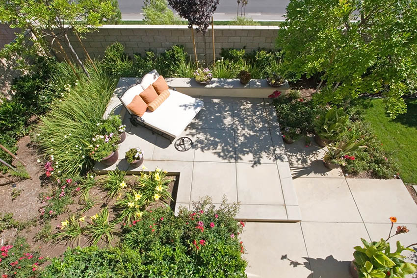 Raised concrete patio with daybed garden landscaping