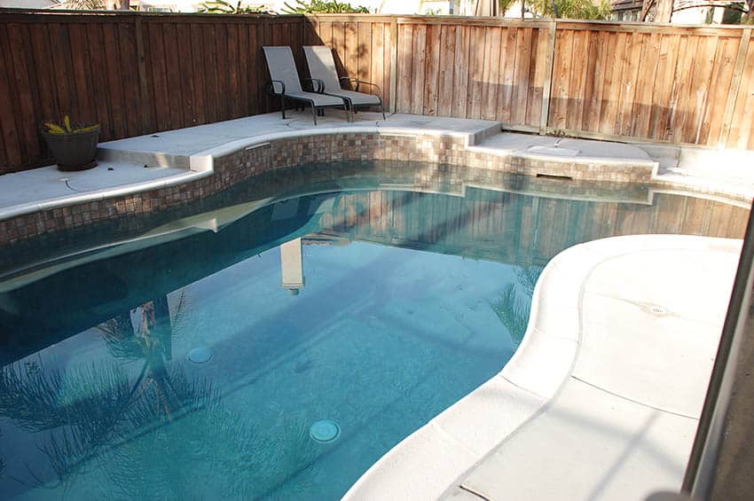 Raised concrete pool patio with lounge chairs