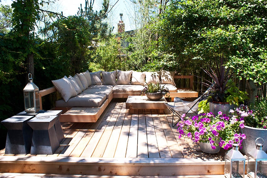 Raised wood deck with corner bench and outdoor cushions