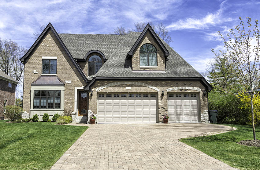 Traditional house with paver driveway three car garage