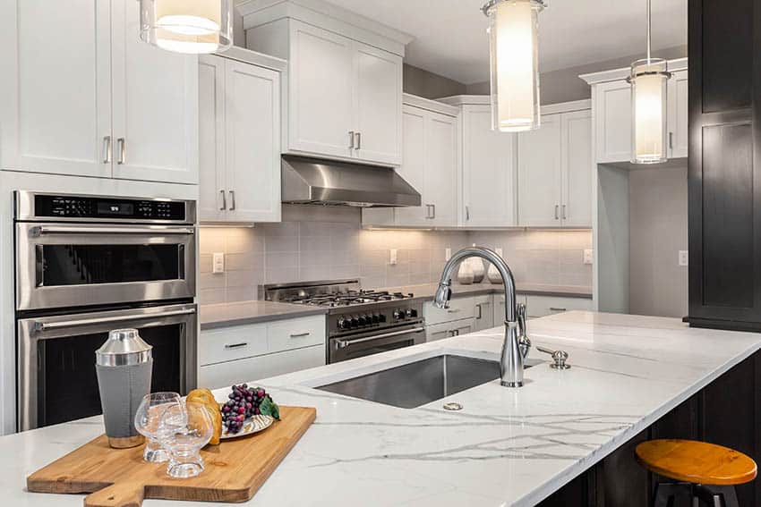 White kitchen with large slab quartz countertop island