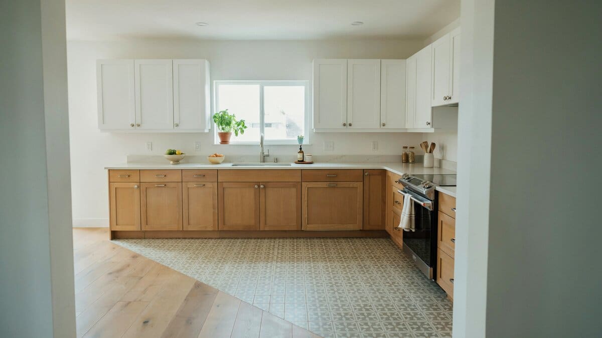 Contemporary kitchen with oak lower cabinets and patterned vinyl linoleum flooring in soft tones
