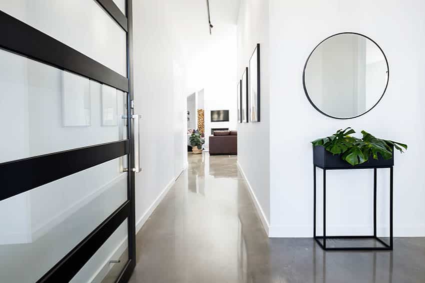 Entryway with white walls, round mirror and accent table