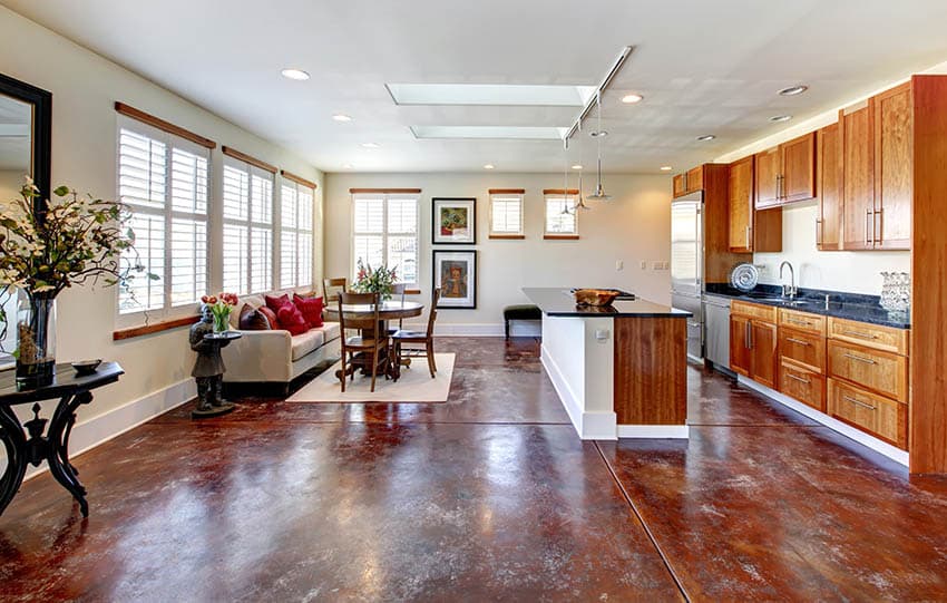 Kitchen with acid stained floors made of concrete, black table with floral vase