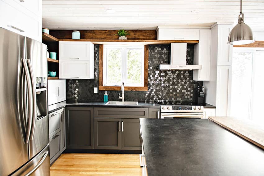 Kitchen with hexagon black backsplash tile, soapstone counters and two tone cabinets