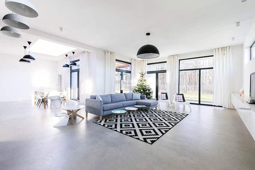 Room with gray floors, dome lights, blue sectional and graphic carpet 