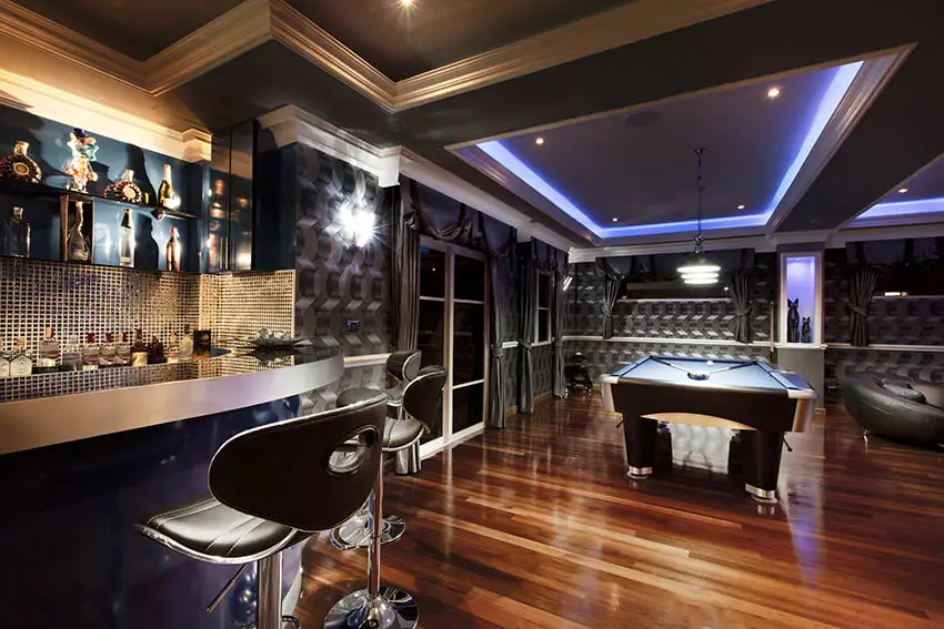 Man cave with cherry hardwood floors home bar pool table tray ceiling lighting