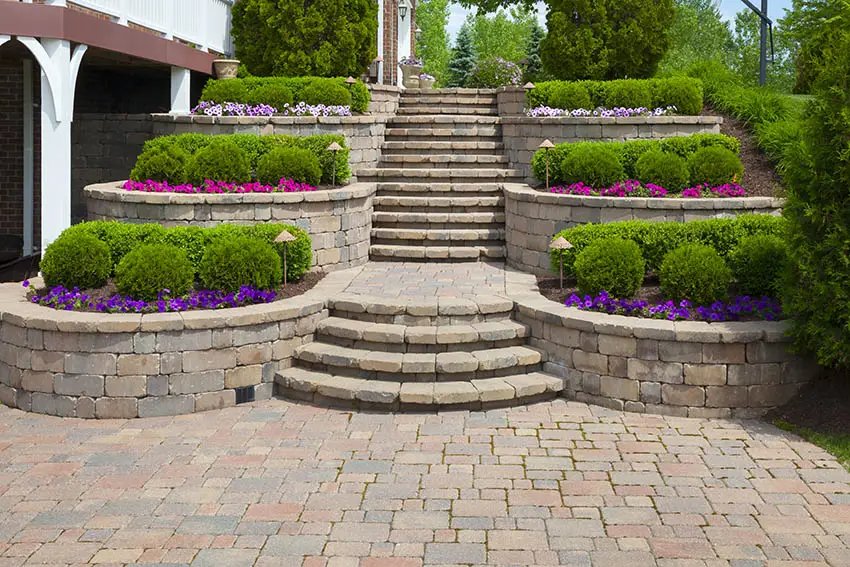 Paver patio with retaining wall and colorful flowers