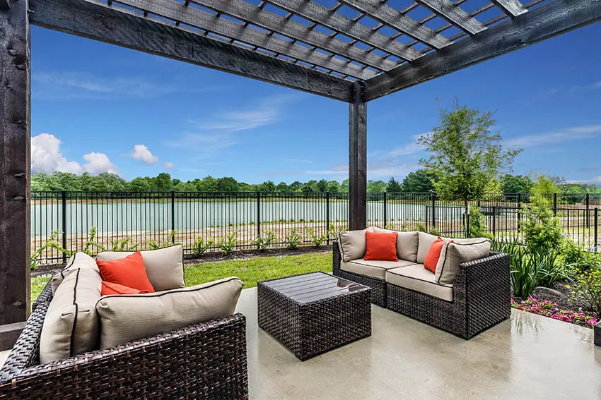 Polished concrete patio with wood pergola black metal fence waterfront views