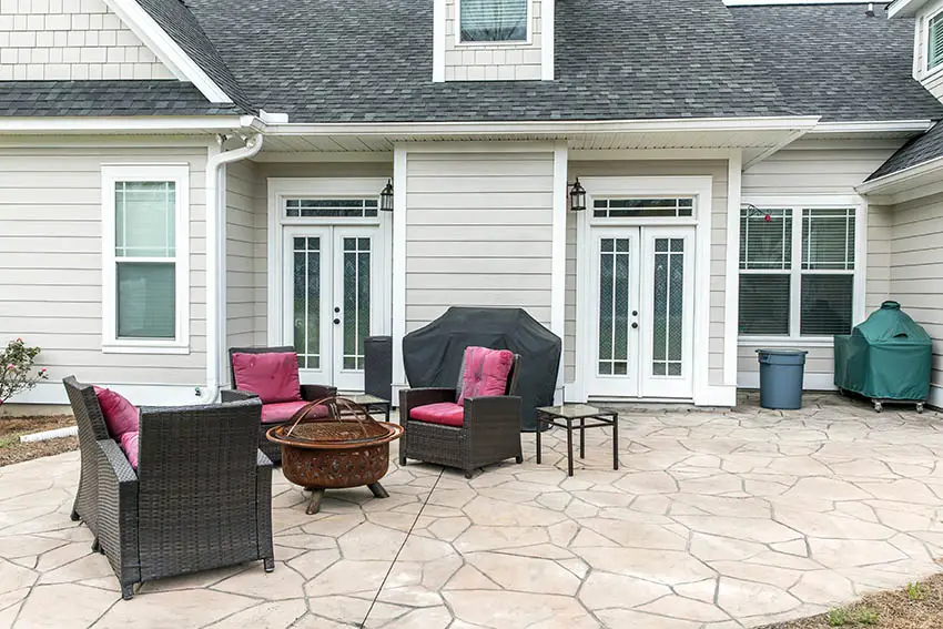 Patio with outdoor table and chairs and house with white siding