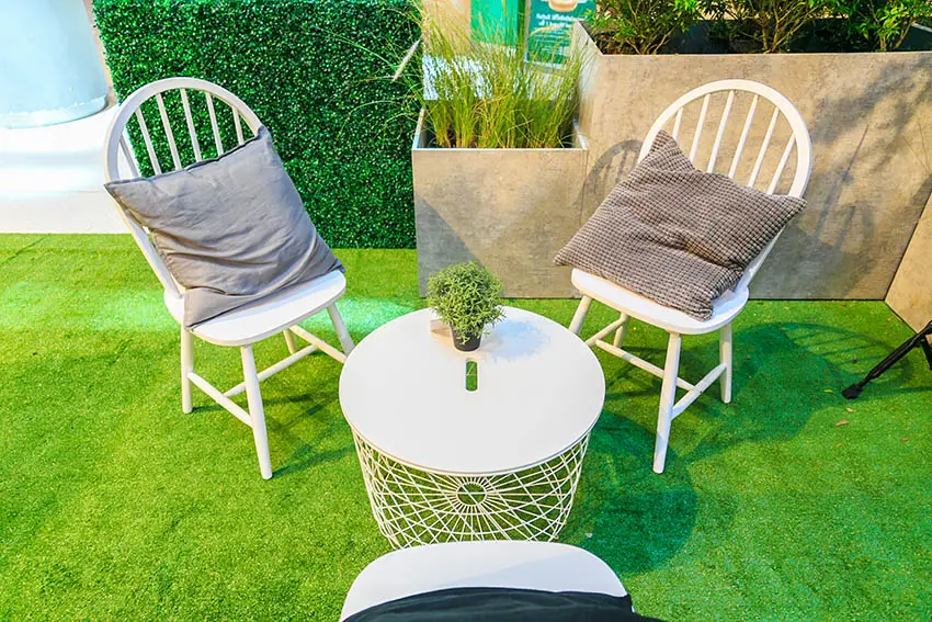 Artificial grass patio with chairs and round table high planter boxes